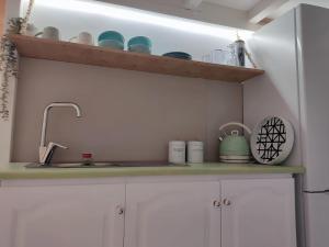 um balcão de cozinha com um lavatório e um frigorífico em Elafonisos Loft A3 em Elafonisos