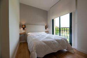 a bedroom with a bed and a large window at Hostal Devesas in O Grove