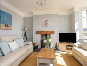 a living room with a couch and a tv at The Old School House in Bodorgan