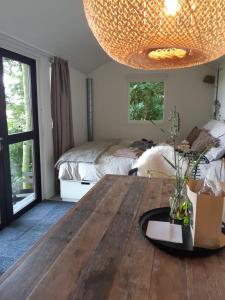 een kamer met een houten tafel en een bed bij Tiny House met sauna, vrij uitzicht, midden in de natuur 