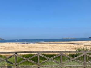 a fence on the beach with the ocean in the background at PLAYA AMERICA MAR in Nigrán