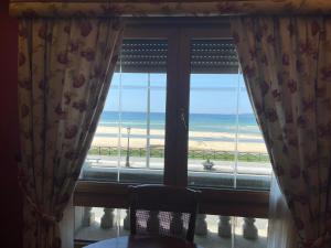 a window with a view of the beach at PLAYA AMERICA MAR in Nigrán