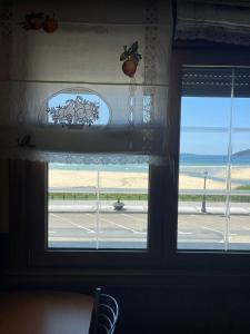 een raam in een kamer met uitzicht op het strand bij PLAYA AMERICA MAR in Nigrán