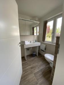 un bagno con un lavandino bianco e un water di FEWO am See Zarrendorf a Zarrendorf