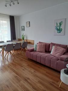 sala de estar con sofá rojo y mesa en APARTAMENT RELAX, en Ełk