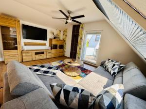 a living room with a couch and a flat screen tv at FeWo Bachlauf mit großer Terrasse in Bad Harzburg