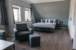 a bedroom with a bed and a chair at Schlei Hotel in Kappeln