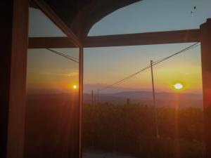 einen Blick auf den Sonnenuntergang von einem Fenster aus in der Unterkunft B&B La Buonora in Sinio