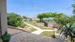 einen Garten mit einem Steingang und einem Pool in der Unterkunft Cozy and charming villa in Tinjan in Tinjan