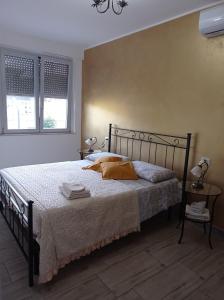 a bedroom with a bed with two lamps and two windows at B&B Villa Nora in Quartu SantʼElena