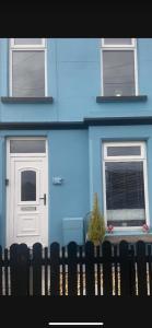 a blue house with two doors and a fence at Sea View Terrace in Donaghadee