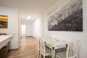 Bonito apartamento a 100 m de la playa في Arico: مطبخ وغرفة طعام مع طاولة وكراسي