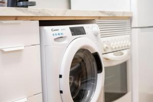 Bonito apartamento a 100 m de la playa في Arico: وجود غسالة ملابس في مطبخ مع كونتر