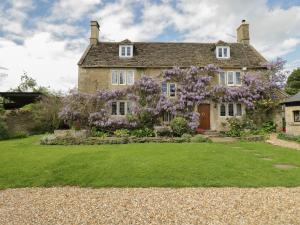 a house with a flowering tree in front of it at Reybridge House in Chippenham
