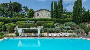 uma piscina em frente a um jardim com uma casa em IL BORGO 16, Emma Villas em Assisi