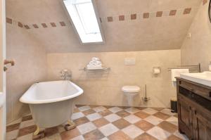 a bathroom with a tub and a toilet and a sink at Vakantiehuis Overleek in Monnickendam +20 photos