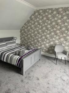 ein Schlafzimmer mit einem großen Bett und einem Stuhl in der Unterkunft Winmar in Inverness