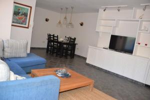 Beachfront Apartment - Tacoronte في سانتا كروث دي تينيريفه: غرفة معيشة مع أريكة زرقاء وطاولة قهوة