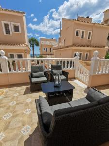 um pátio com sofás e uma mesa na varanda em Dream villa with sea views and swimming pool! em Guardamar del Segura