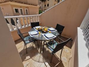 uma mesa e cadeiras na varanda de um apartamento em Dream villa with sea views and swimming pool! em Guardamar del Segura