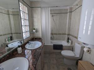 uma casa de banho com um lavatório, um WC e uma banheira em Dream villa with sea views and swimming pool! em Guardamar del Segura