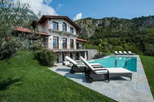 トレメッツォにあるVilla Fiordalisoの庭に椅子とスイミングプールがある家