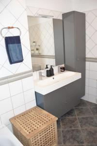 baño con lavabo, espejo y taburete de mimbre en Beachfront Apartment - Tacoronte, en Santa Cruz de Tenerife