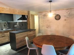uma cozinha e sala de jantar com uma mesa de madeira e cadeiras em Chez pierre et Julie em Thollon