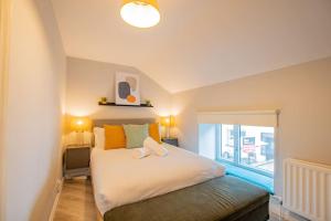 een slaapkamer met een groot wit bed en een raam bij Cozy Retreat in The City Centre in Galway