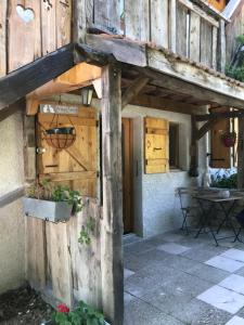 uma entrada em madeira para uma casa com uma porta de madeira em Chez pierre et Julie em Thollon