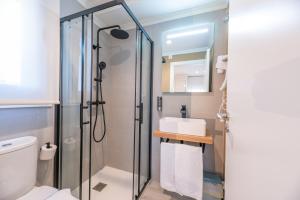 ein Bad mit einer Dusche, einem WC und einem Waschbecken in der Unterkunft Hostal Devesas in O Grove