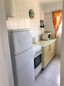 a kitchen with a white refrigerator and a microwave at Acuario shared flat piso compartido est partagé الشقة مشتركة in Benalmádena
