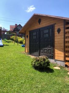 un garage con una porta nera su una casa di Zamajerz Nad Zalewem a Niedzica Zamek