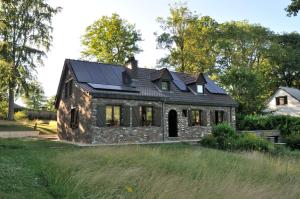 ein altes Steinhaus mit Sonnenkollektoren darauf in der Unterkunft Suite familiale avec 2 Chambres dans une villa - quartier vert et boisé - 5 kms de Namur in Namur