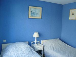 a bedroom with blue walls and two beds and a lamp at En Dro, Rez-de-jardin à Carnac in Carnac