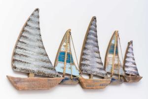 a group of four miniature sailboats with snow on them at Ferienwohnungen Blaues Haus in Bensersiel