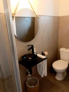 bagno con servizi igienici, lavandino e specchio di Retiro da Cava, piscina privada a Oleiros