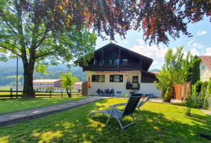 uma casa com uma cadeira no quintal em Haus Denneberg em Oberstaufen