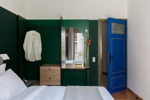 ein Schlafzimmer mit einer blauen Tür und einer grünen Wand in der Unterkunft Nileos House in Athen