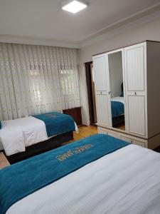 ウズンギョルにあるKaragoz Apart Pansiyonのベッドルーム1室(ベッド2台、鏡付)