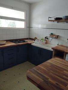 een keuken met blauwe kasten, een wastafel en een raam bij porz montroulez in Morlaix