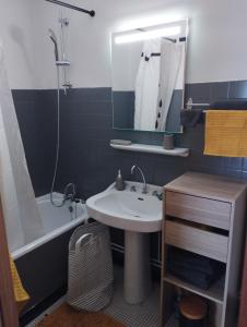 een badkamer met een wastafel, een bad en een spiegel bij porz montroulez in Morlaix
