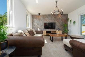 Una sala de estar con un sofá y un televisor. en Villa La Aurora ZadarVillas, en Murvica