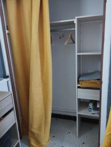 een geel gordijn in een kamer met een kast bij porz montroulez in Morlaix
