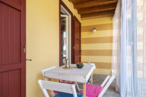 - une table et des chaises sur la terrasse couverte d'une maison dans l'établissement Le Porte Blu, à Passirano
