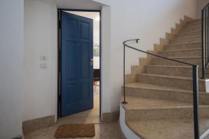 a blue door in a hallway with stairs at Le Porte Blu in Passirano