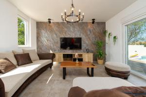 Una sala de estar con un sofá y un televisor. en Villa La Aurora ZadarVillas, en Murvica