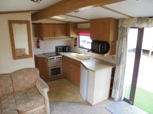 a kitchen in an rv with a sink and a stove at Promenade: Retreat:- 4 Berth, Access to the beach in Ingoldmells