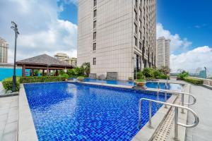 a swimming pool in front of a tall building at Sheraton Zhongshan Hotel in Zhongshan