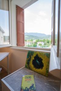 un libro sentado en una mesa junto a una ventana en Casa dello Studente en Vittorio Veneto